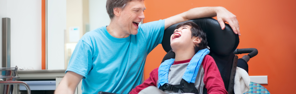 young boy with severe disabilities and his caregiver in a group home