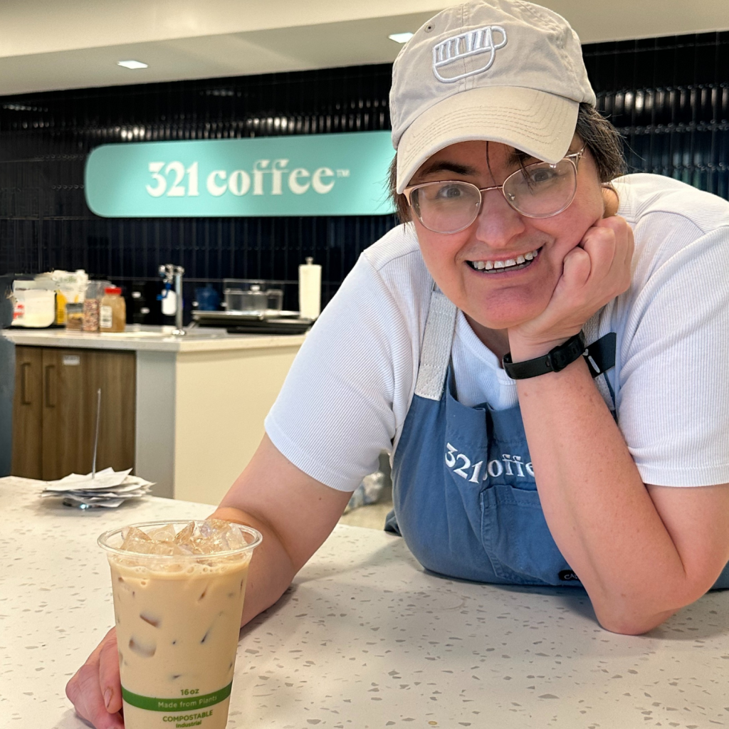 Barista with iced coffee at counter