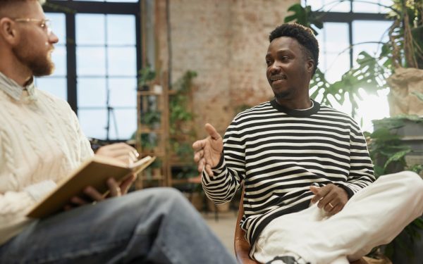 Two people engaged in conversation indoors.