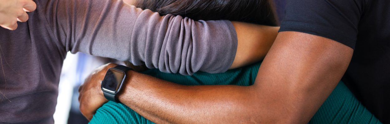 People embracing in an offering of family peer support.