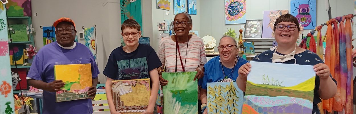 Group displaying colorful artwork indoors.