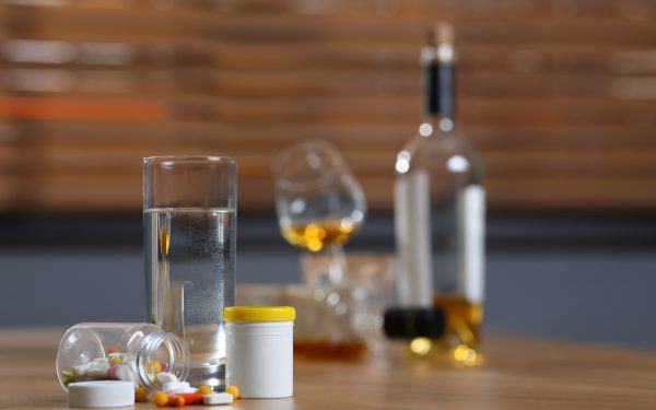 Pills, glass of water, alcohol