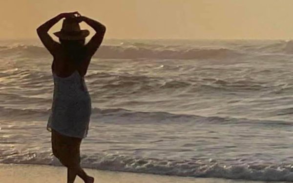 Silhouette walking on beach at sunset