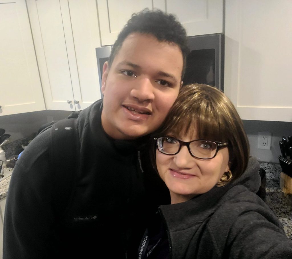 Two people smiling in a kitchen.
