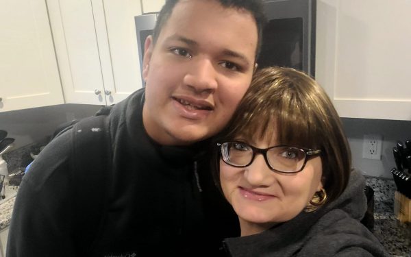 Two people smiling in a kitchen.