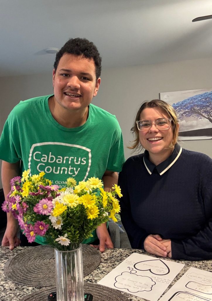 Two people smiling with flowers.