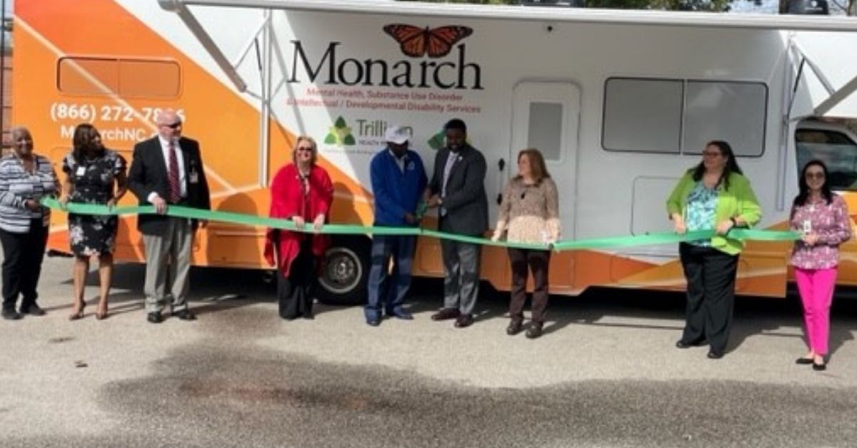 Community partners cut the green ribbon in front of Monarch's Mobile Integrated Care Clinic to serve Bertie, Gates and Hertford counties.