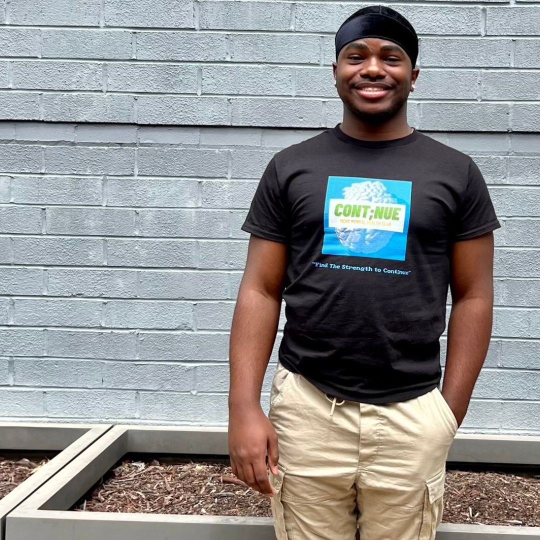 Mallard Creek High School Student Anthony Anderson wearing the Cont;nue Mental Health Club T-shirt.