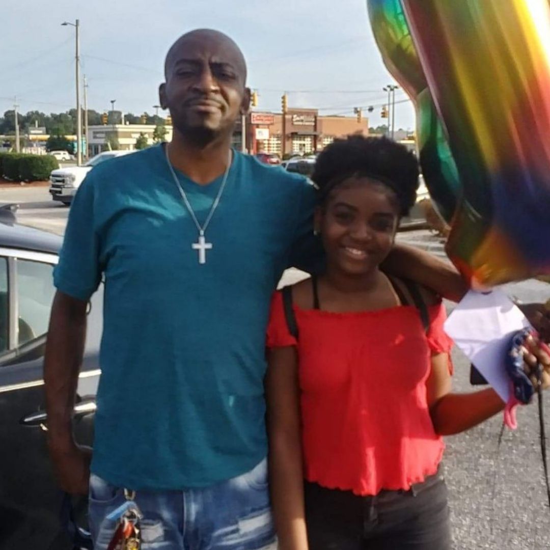 Person supported Clarence Smith enjoys time with his teen daughter during a family celebration.