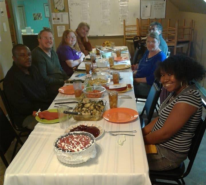 Clubhouse PSR Thanksgiving diners pose before eating the holiday feast.