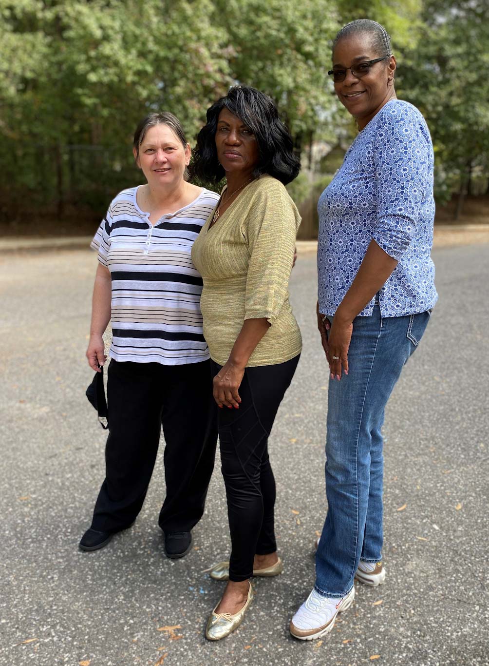 Residential Team Leader Angela Pitcher, left, Travis Adams, center, and Tammie Rorie, right, pose outside Monarch’s Grand Oaks apartments. 