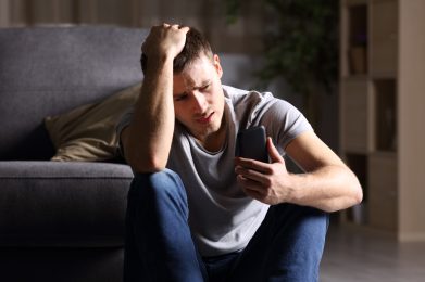man holding phone with worried look on face